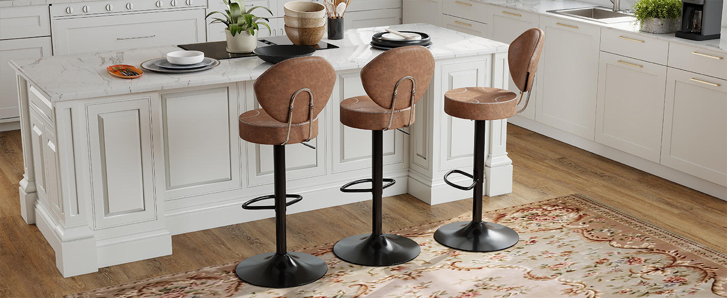 Modern kitchen interior with white cabinets, featuring brown leather bar stools with black metal bases arranged along a kitchen island.