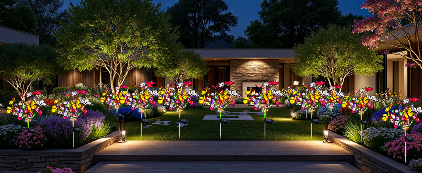 Nighttime garden landscape lighting scene featuring illuminated flower beds with colorful blooms and pathway lights creating ambient outdoor lighting.