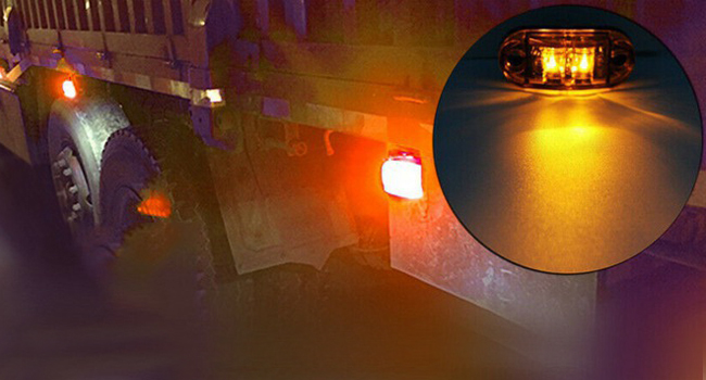 Chasis de vehículo con luces ámbar y amarillas encendidas. Un inserto de primer plano muestra una emisión de luz amarilla brillante de una fuente circular.