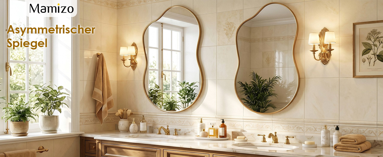 Le texte indique « Mamizo » et « Asymmetrischer Spiegel » (miroir asymétrique). Deux miroirs décoratifs de forme ovale avec cadres dorés montés sur le mur de la salle de bain beige au-dessus du lavabo avec porte-serviettes et appliques murales.