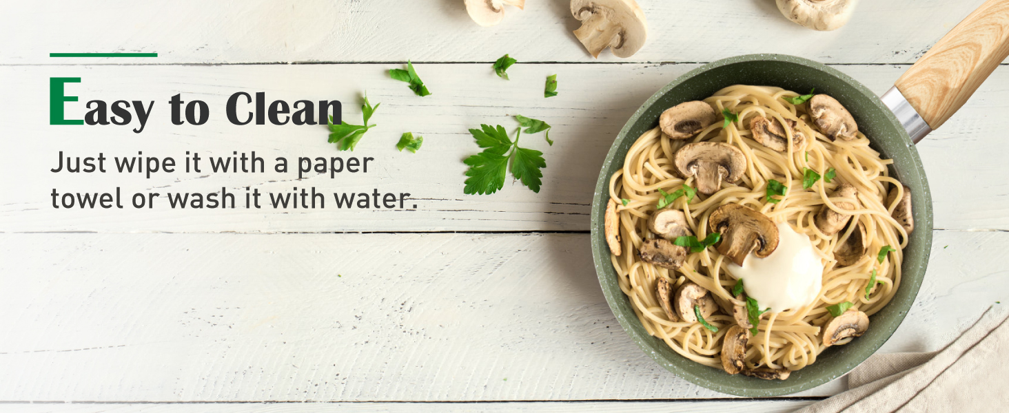 Green frying pan with pasta dish, highlighting easy cleaning feature. Text states 'Easy to Clean' and cleaning instructions. Wooden background with herbs visible.