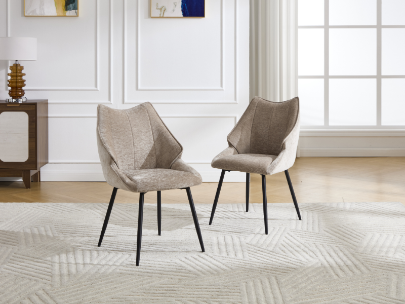 Cadre de salon moderne avec plusieurs fauteuils d'appoint rembourrés gris disposés sur un tapis à motifs géométriques de couleur claire sur des murs blancs.