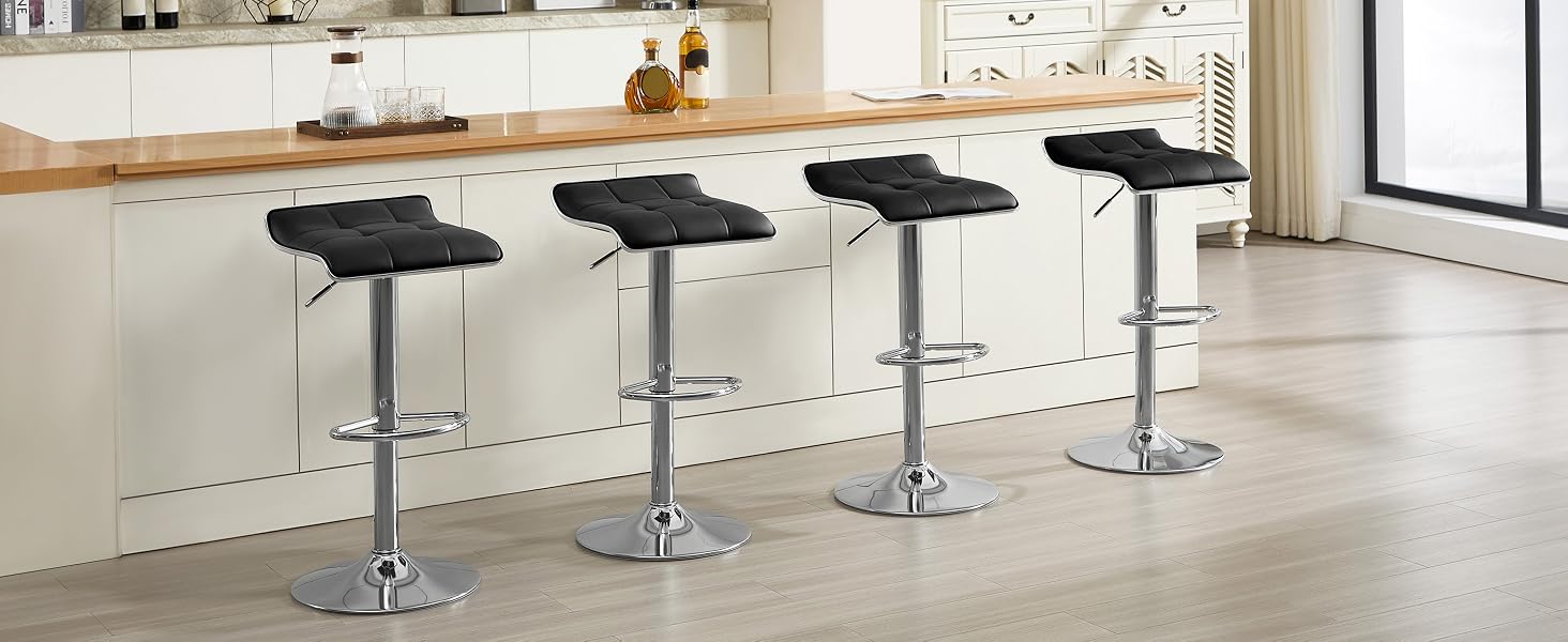 Fila di quattro moderni sgabelli da bar regolabili neri con basi cromate lungo il bancone bianco in uno spazio interno minimalista