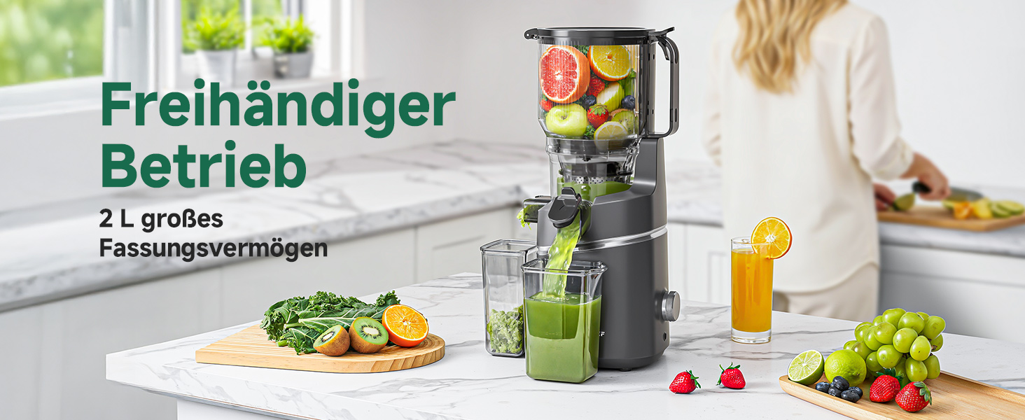 Der Text lautet 'Freihändiger Betrieb' und '2 L grüne Fassungsvermögen'. Schwarzer Mixer mit grünen Akzenten auf der Küchentheke mit frischen Zutaten (Gemüse, Obst) und einem Glas mit Getränken daneben.