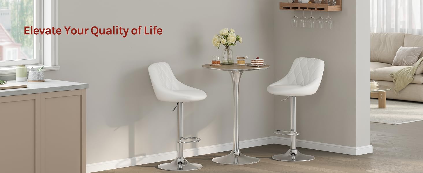 Text reads 'Elevate Your Quality of Life'. Modern interior room with white bar stools, small round table, and minimalist furniture against neutral walls.