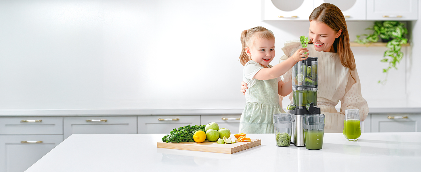 Vertikale Saftpresse auf weißer Küchentheke mit frischen Produkten wie Gurken und Zitrusfrüchten auf einem Holzschneidebrett