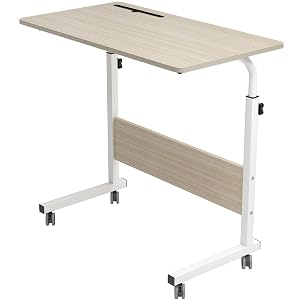 Adjustable height desk with light wood top and white metal frame. Features wheels for mobility and a lower shelf for storage.
