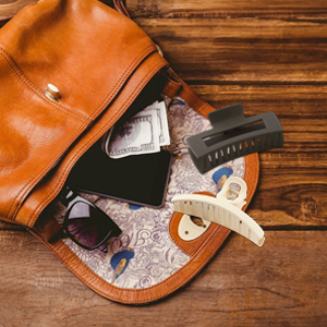 Open brown leather bag containing baby care items including a pacifier and other accessories on wooden surface.