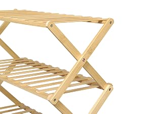 Wooden folding rack or shelf. Light-colored wood with slatted design. X-shaped sides for collapsible structure. Multiple tiers for storage or display.