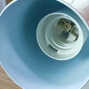 Gros plan d'un abat-jour bleu clair avec une prise électrique visible et une prise à l'intérieur
