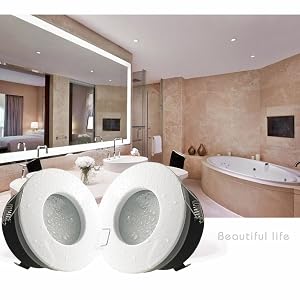Modernes Badezimmerinterieur mit weißen Wänden, modernen Armaturen und mehreren eleganten Toiletten in einer ausstellungsraumähnlichen Umgebung mit Einbaubeleuchtung.