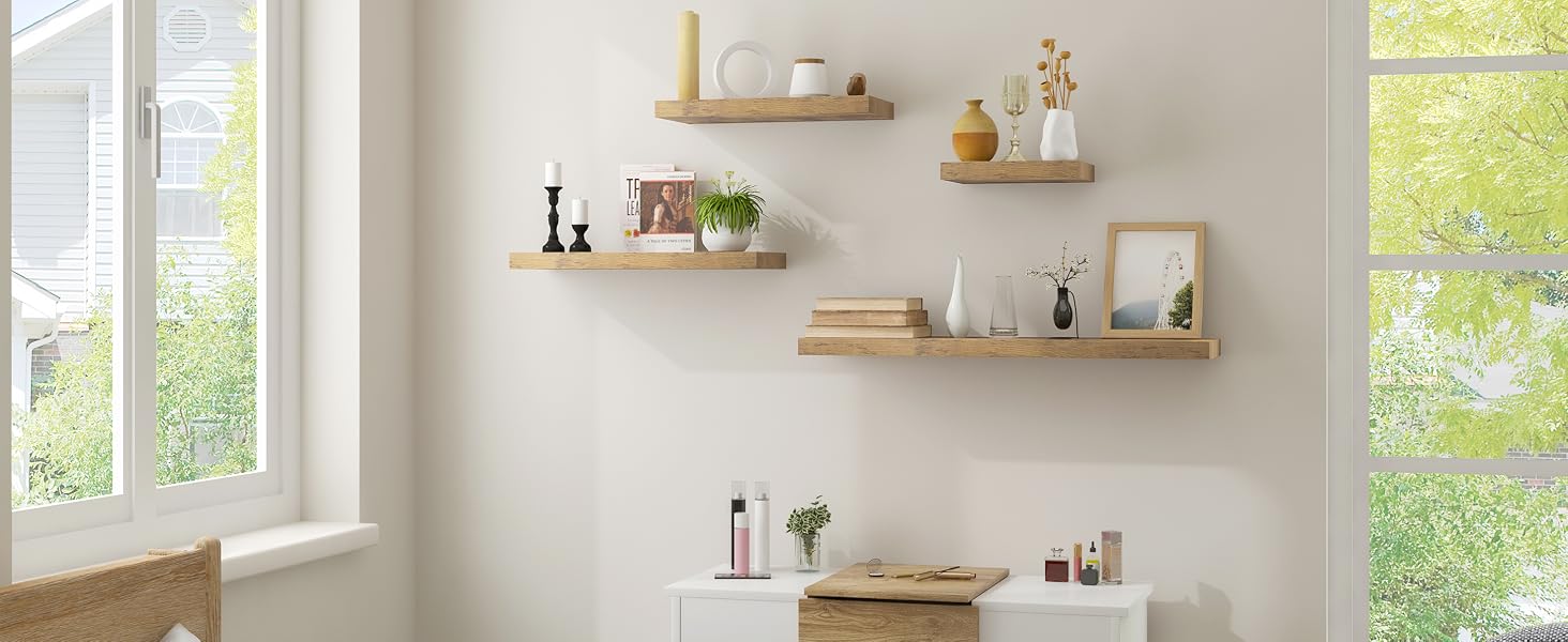 Light-filled room with white walls, featuring wooden floating shelves and a small white desk. Plants and decorative items adorn the shelves.