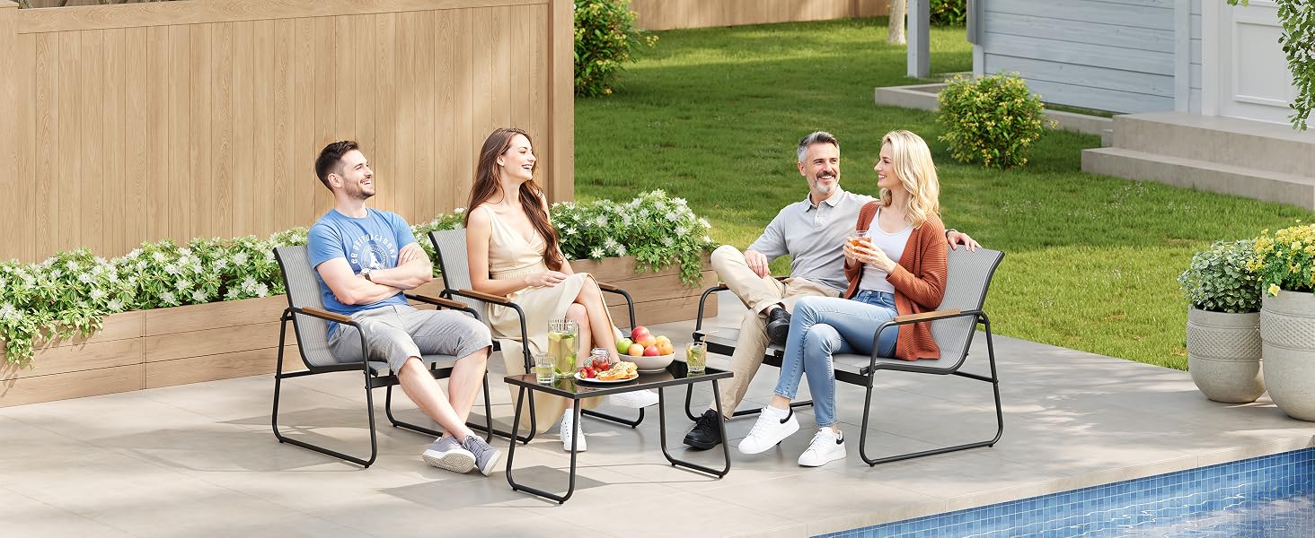Four adults seated in gray folding camping chairs arranged in circle outdoors beside swimming pool, with house and fence visible in background.
