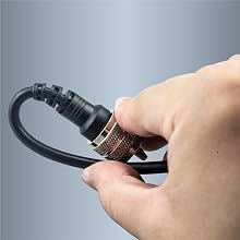 Close-up of hands adjusting a black flexible connector or adapter with metallic copper-colored accent ring.