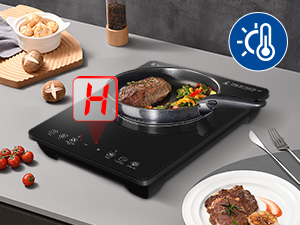 Schwarzes Induktionskochfeld mit Pfanne mit gekochtem Fleisch und Gemüse, sichtbares Temperaturkontrollsymbol, Holzschneidebrett mit Snacks im Hintergrund