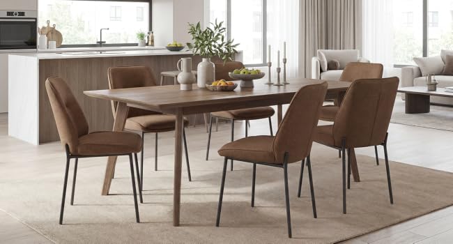 Identical modern dining set as Image 1: wooden table with four brown upholstered chairs on beige rug, contemporary interior setting with kitchen and living areas visible.