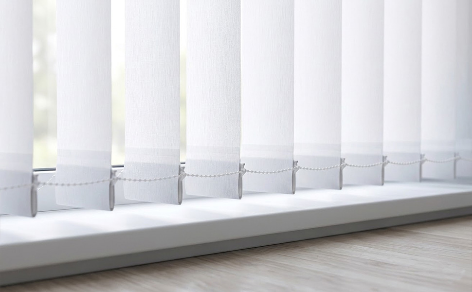 Interior space with multiple white vertical blinds installed, showing full-length window coverage and uniform alignment across windows.