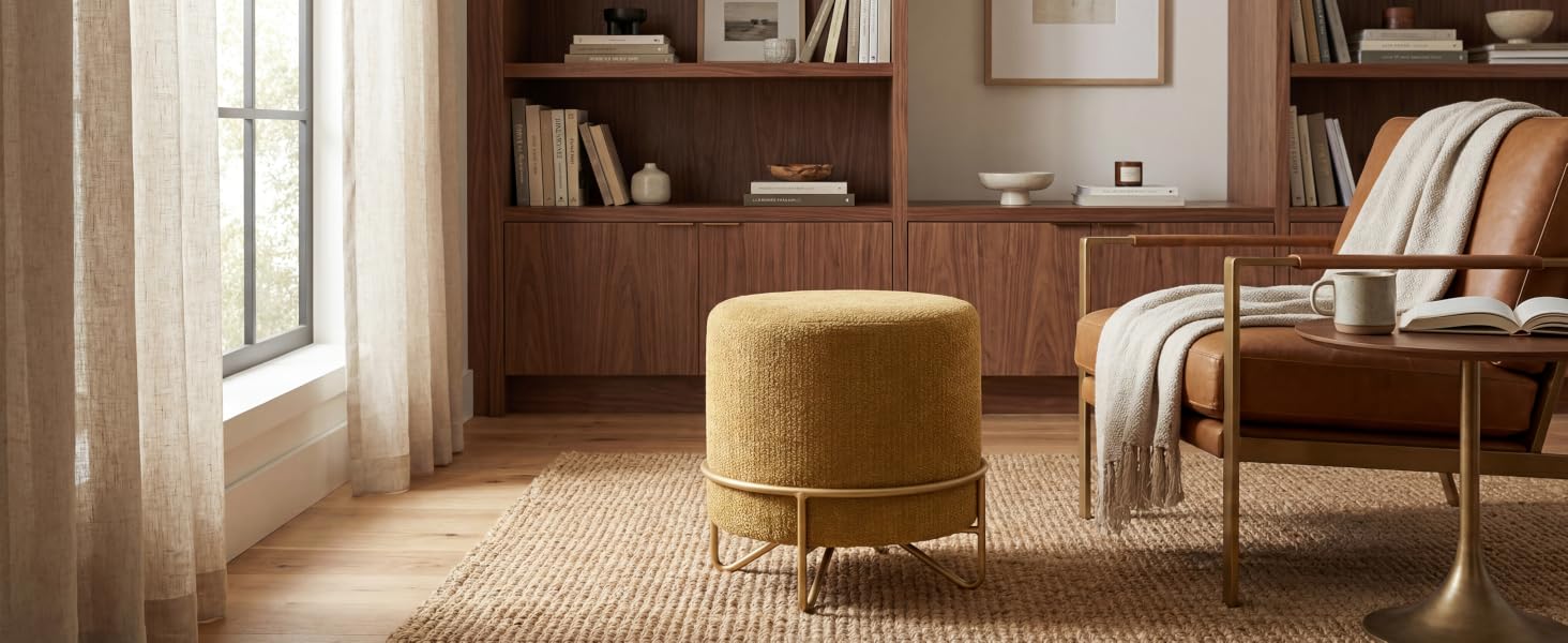Ambiente interno con mobili in legno, caratterizzato da un pouf/pouf giallo senape vicino a una finestra con luce naturale e scaffali in legno incorporati.