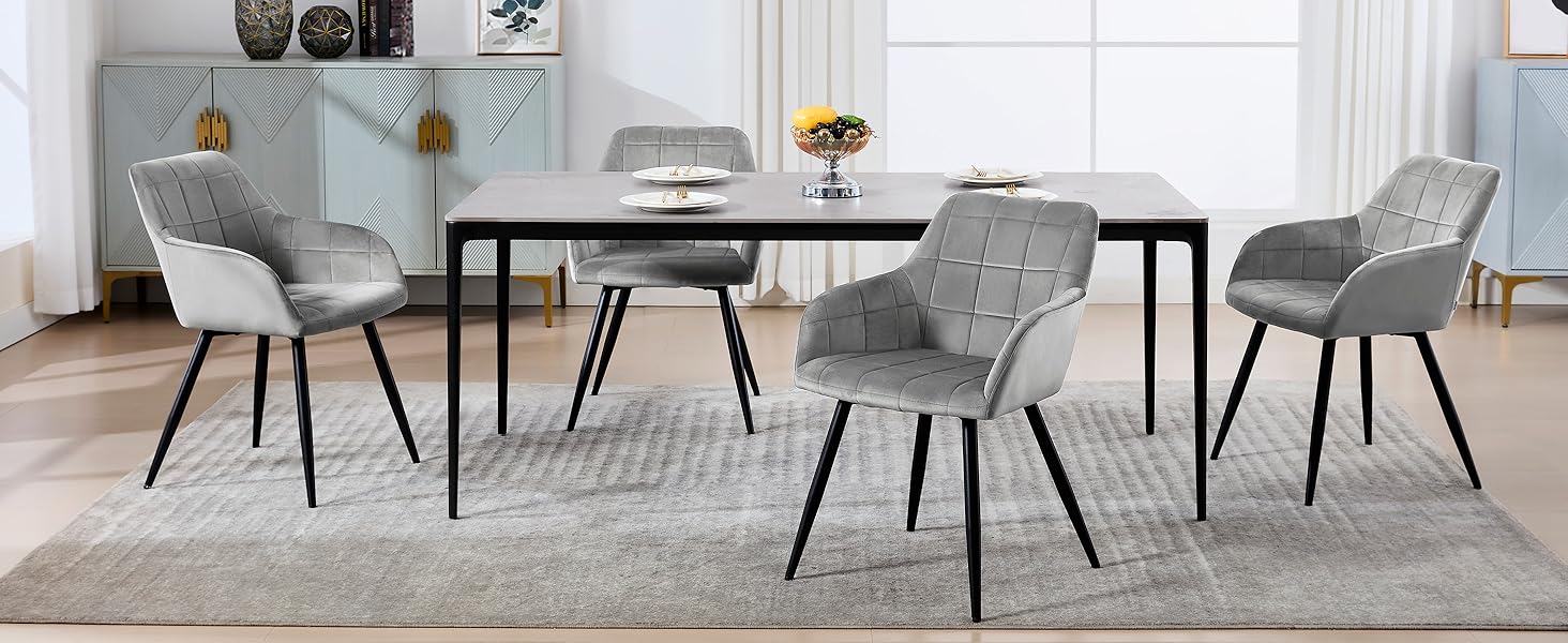 con mesa redonda blanca y cuatro sillas tapizadas en gris. Diseño elegante en una habitación luminosa y minimalista.
