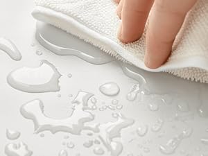 una persona que limpia una toalla blanca con gotas de agua.