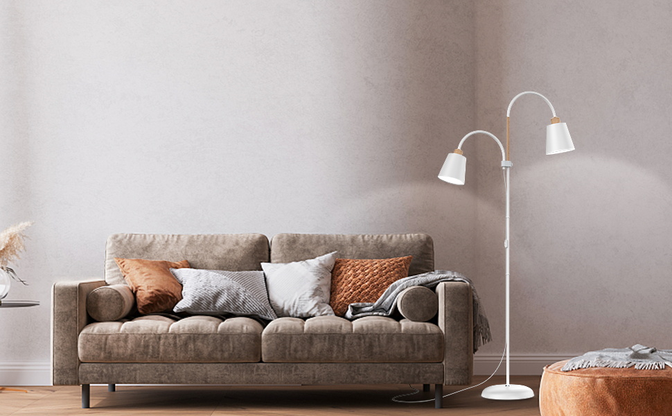 eine graue Couch mit Kissen und einer Lampe.