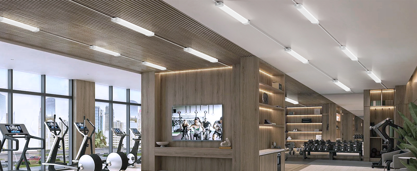 Modernes Fitness-Interieur mit holzgetäfelten Wänden, Kardiogeräten und großen Fenstern. Leuchtstoffbeleuchtung und an der Wand befestigter Bildschirm sind sichtbar