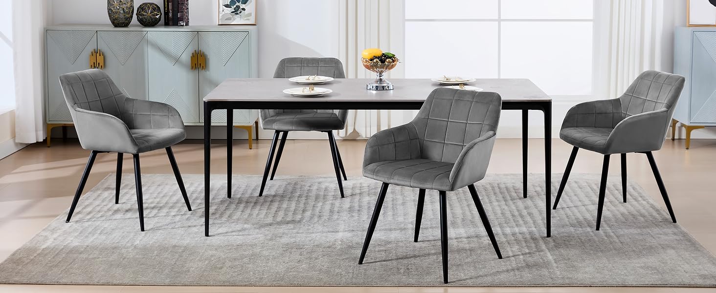 con mesa rectangular negra y cuatro sillas de comedor tapizadas en gris con respaldos curvos y patas de metal cónicas