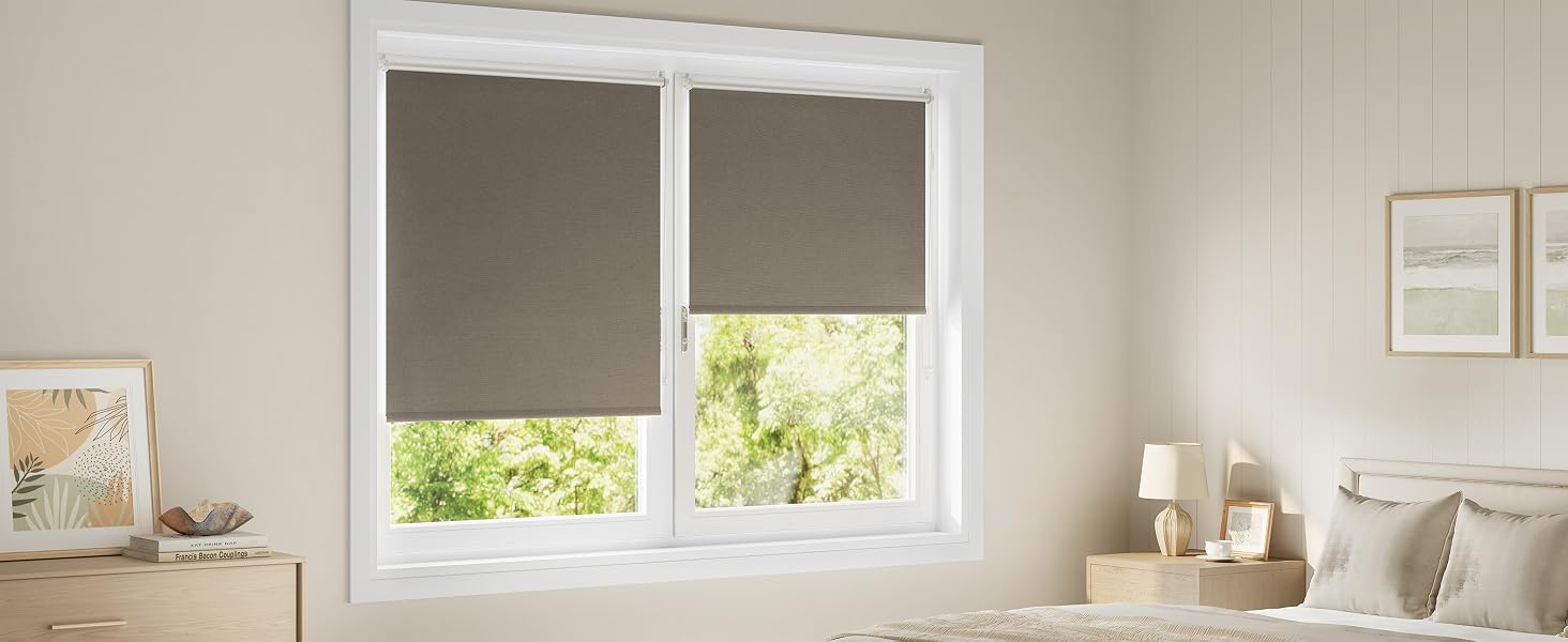 Interior de cocina moderno con gabinetes blancos y ventanas con cortinas enrollables en un tono neutro, que demuestra el control de la luz natural en un espacio limpio y luminoso.