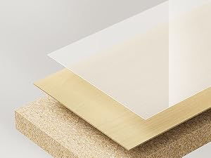 Primo piano di campioni di materiale stratificato che mostrano trame bianche, beige e in sughero o pannelli truciolari disposte in una formazione a gradini.