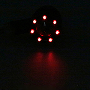Circular arrangement of seven glowing red LED lights against a dark background.
