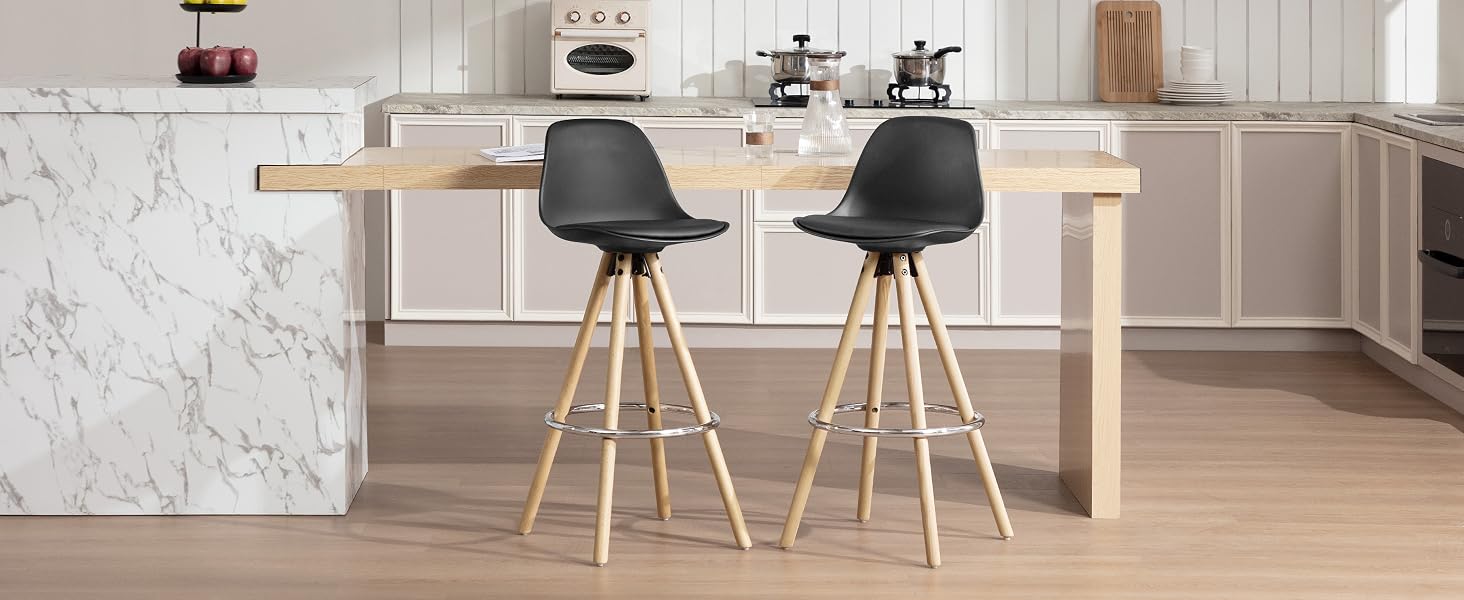 Cucina moderna con isola in marmo, bancone in legno e due sgabelli da bar neri con gambe in legno. Macchine da caffè visibili sullo sfondo