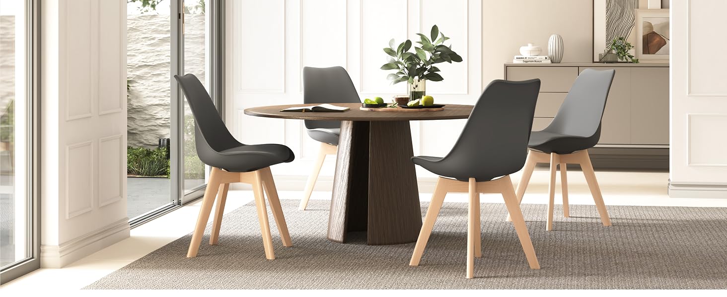 Juego de comedor moderno con mesa redonda de madera y cuatro sillas tapizadas en gris con patas de madera, dispuestas en un luminoso espacio interior