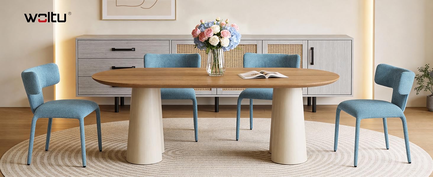 Il testo recita «Waltu». Moderna sala da pranzo con tavolino rotondo bianco e diverse sedie imbottite blu su un tappeto a motivi geometrici.