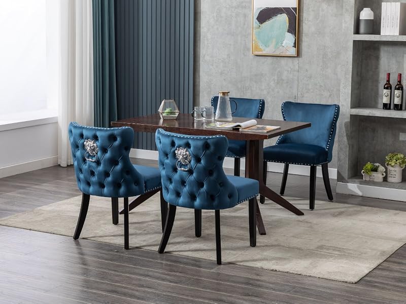 Essgruppe mit rechteckigem Holztisch und vier getufteten blauen Samtstühlen. Modernes Design in einem Raum mit grauen Wänden und eingebauten Regalen