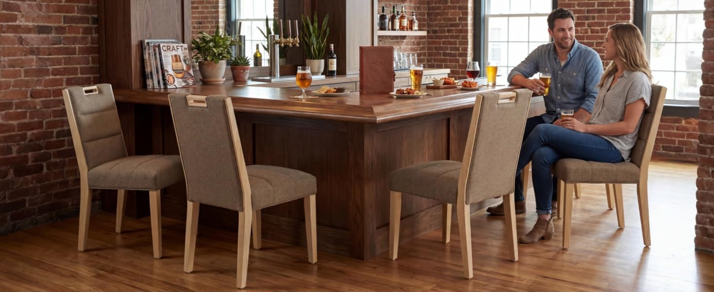 Interno della sala da pranzo con tavolo in legno e sedie imbottite, che mostra un ambiente da pranzo informale.