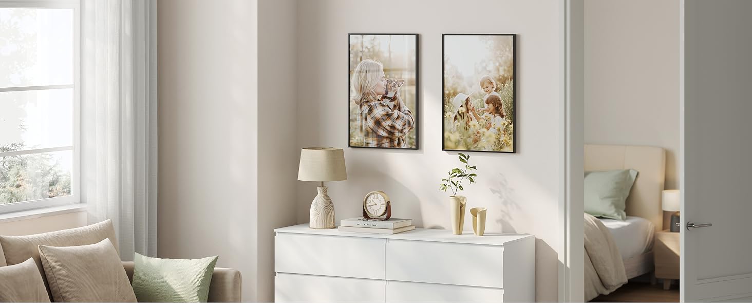 Interno del soggiorno con opere d'arte incorniciate su pareti bianche, con illuminazione naturale ed elementi decorativi moderni.