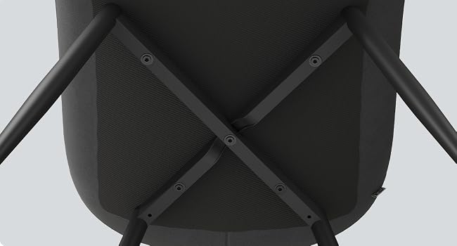Primo piano della superficie strutturata nera che mostra una struttura di supporto incrociata, sembra essere la parte inferiore di mobili o attrezzature.