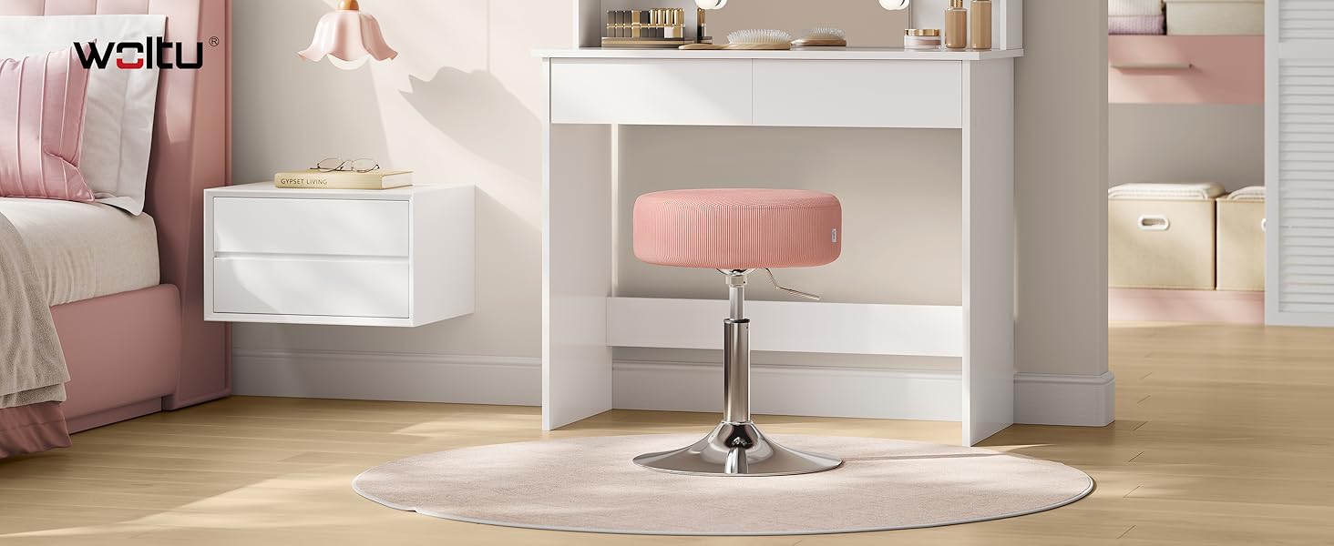 El texto dice «WÖHRL».
[SENTENCE 12] Decoración moderna de diseño interior que muestra un baño o tocador de temática rosa y blanca con espejo circular y alfombra de felpa.