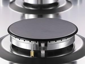 Gros plan du brûleur de poêle en acier inoxydable. Surface de cuisson circulaire avec anneaux concentriques et distributeur de flamme central visible.
