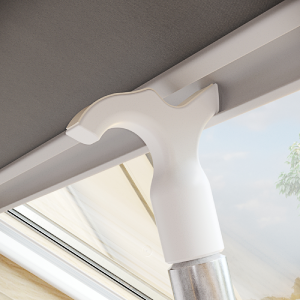 White plastic adjustable rod or pole mount attached to an indoor ceiling or wall corner, showing mounting hardware.