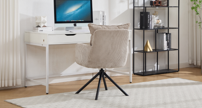 Modern home office setup with white desk, beige chair, iMac computer display, and black metal shelf unit against light curtained wall.