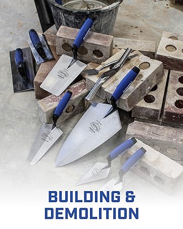 Text reads 'BUILDING &amp; DEMOLITION'. Collection of construction tools including trowels and masonry implements with blue handles against concrete surface.