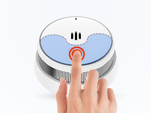Détecteur de fumée circulaire ou dispositif d'alarme avec bouton central enfoncé par un doigt, avec panneau indicateur bleu clair.