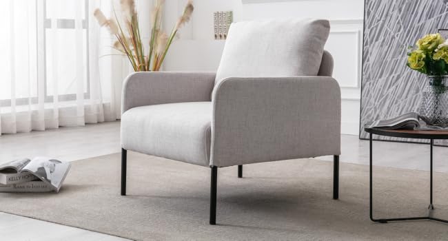 Sillón tapizado en gris claro con finas patas de metal negro.