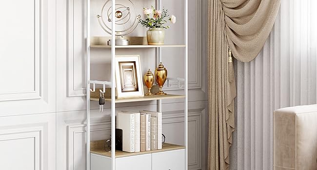 Scaffale decorativo in metallo bianco a più livelli, che espone libri, piante e oggetti ornamentali contro una parete di colore chiaro