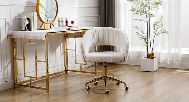 Configuration de bureau à domicile moderne comprenant une chaise de bureau capitonnée à canaux de couleur crème avec base dorée sur roulettes, associée à un bureau à cadre doré et à un miroir circulaire