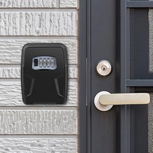 Black key safe box with digital combination lock mounted on textured wall next to door handle and lock.