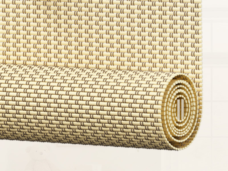 Vue rapprochée d'un tapis ou d'un tapis tissé en fibres naturelles présentant un motif géométrique répétitif, enroulé et déroulé pour en faire ressortir la texture et la structure.