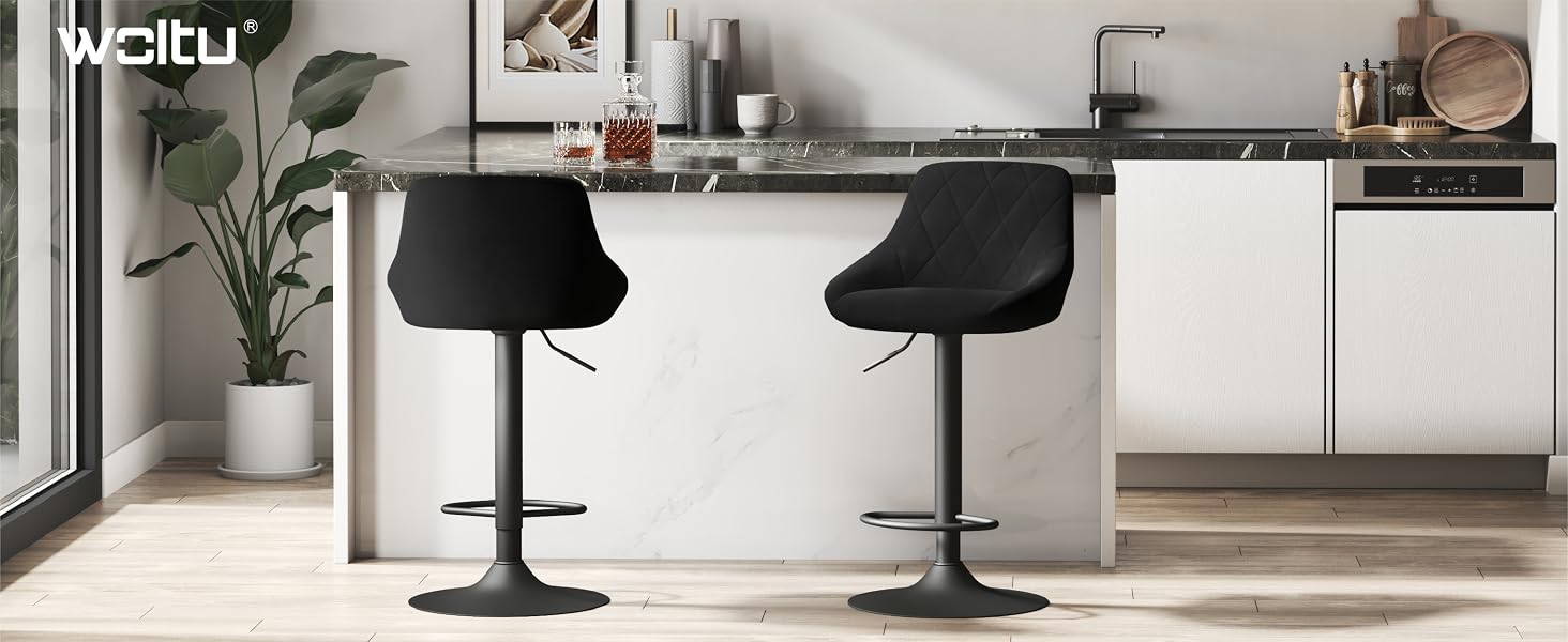 Cocina moderna con gabinetes blancos, encimera y dos taburetes negros ajustables. Planta en maceta y decoración visibles