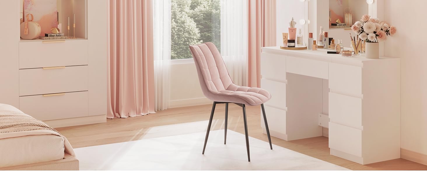 una sedia rosa davanti a una finestra.